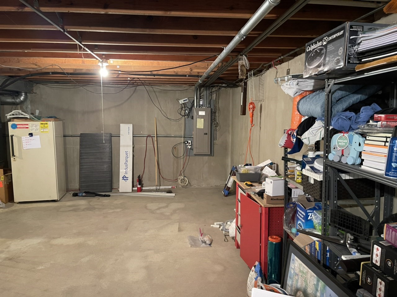 Basement prior to remodel with unfinished floors, walls, and ceiling