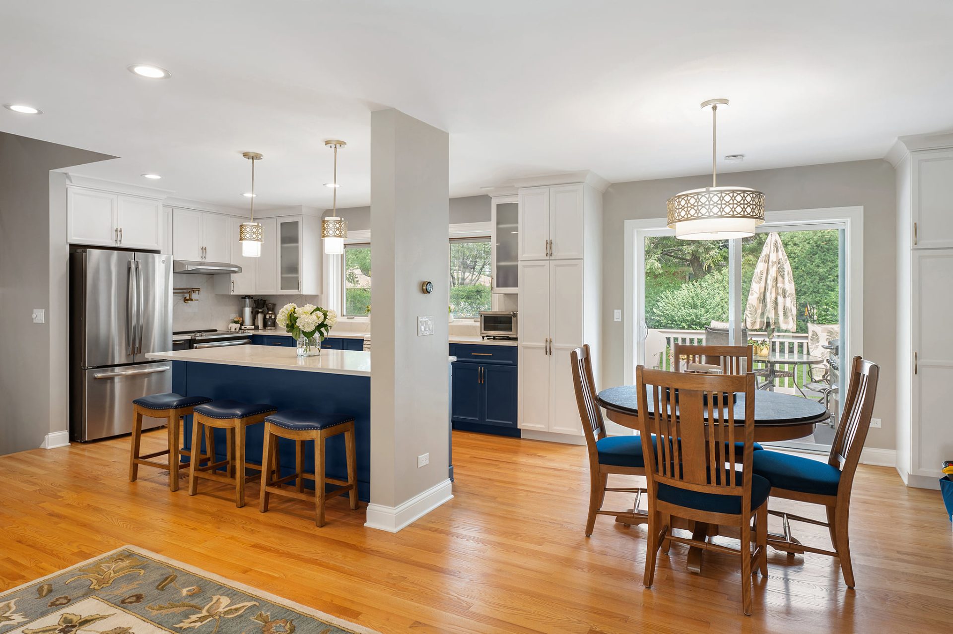 Remodeled kitchen with dining area, white quartz countertop, and navy cabinets
