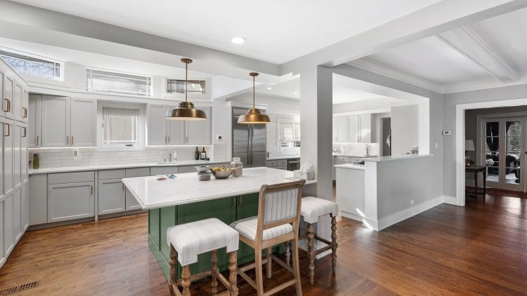 Open-concept kitchen home addition with a green island in Glenview, IL