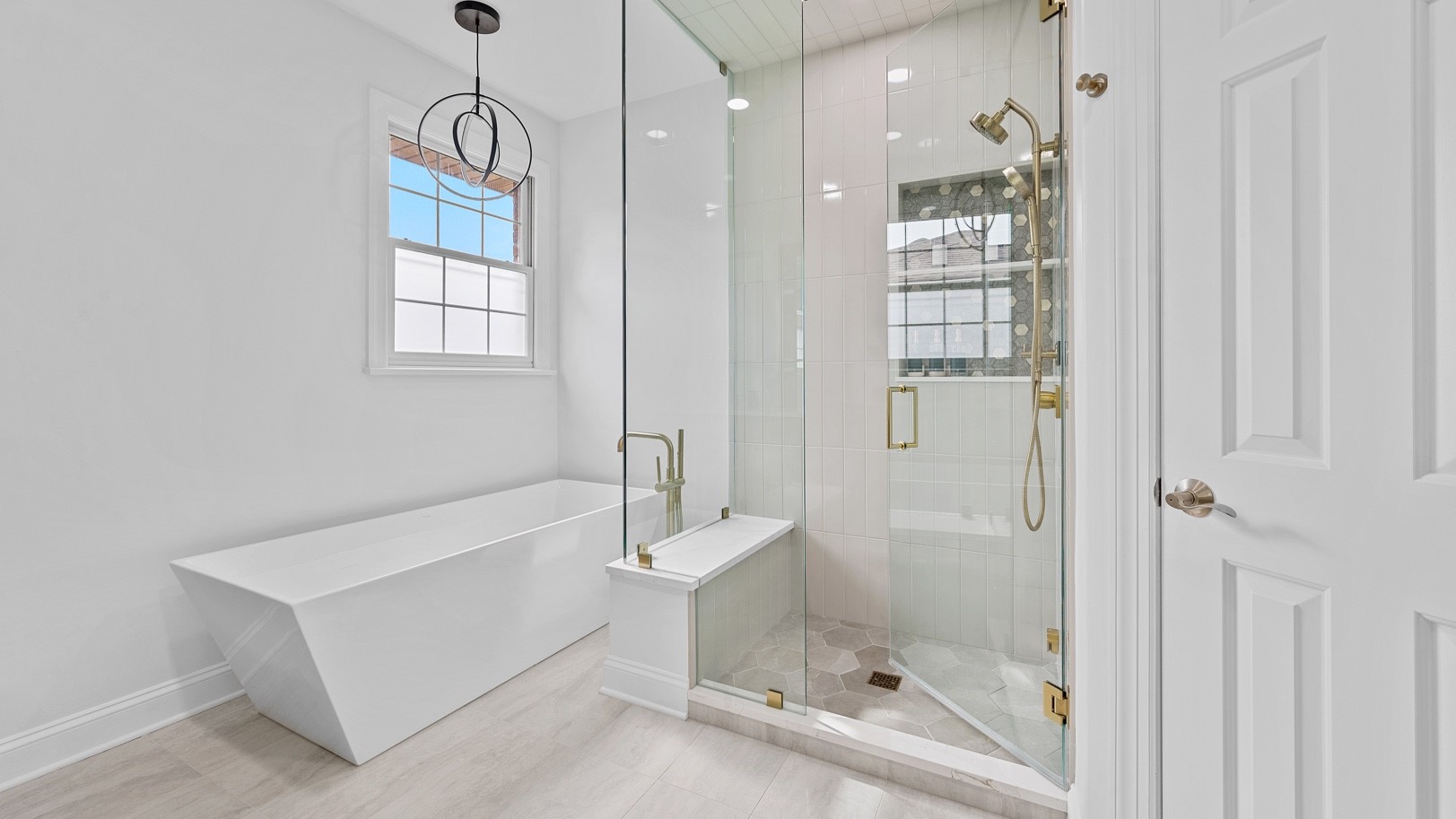 Newly remodeled Oak Park, IL bathroom with beautiful white tile flooring, large white bathtub, and new glass shower unit by 4Ever Remodeling