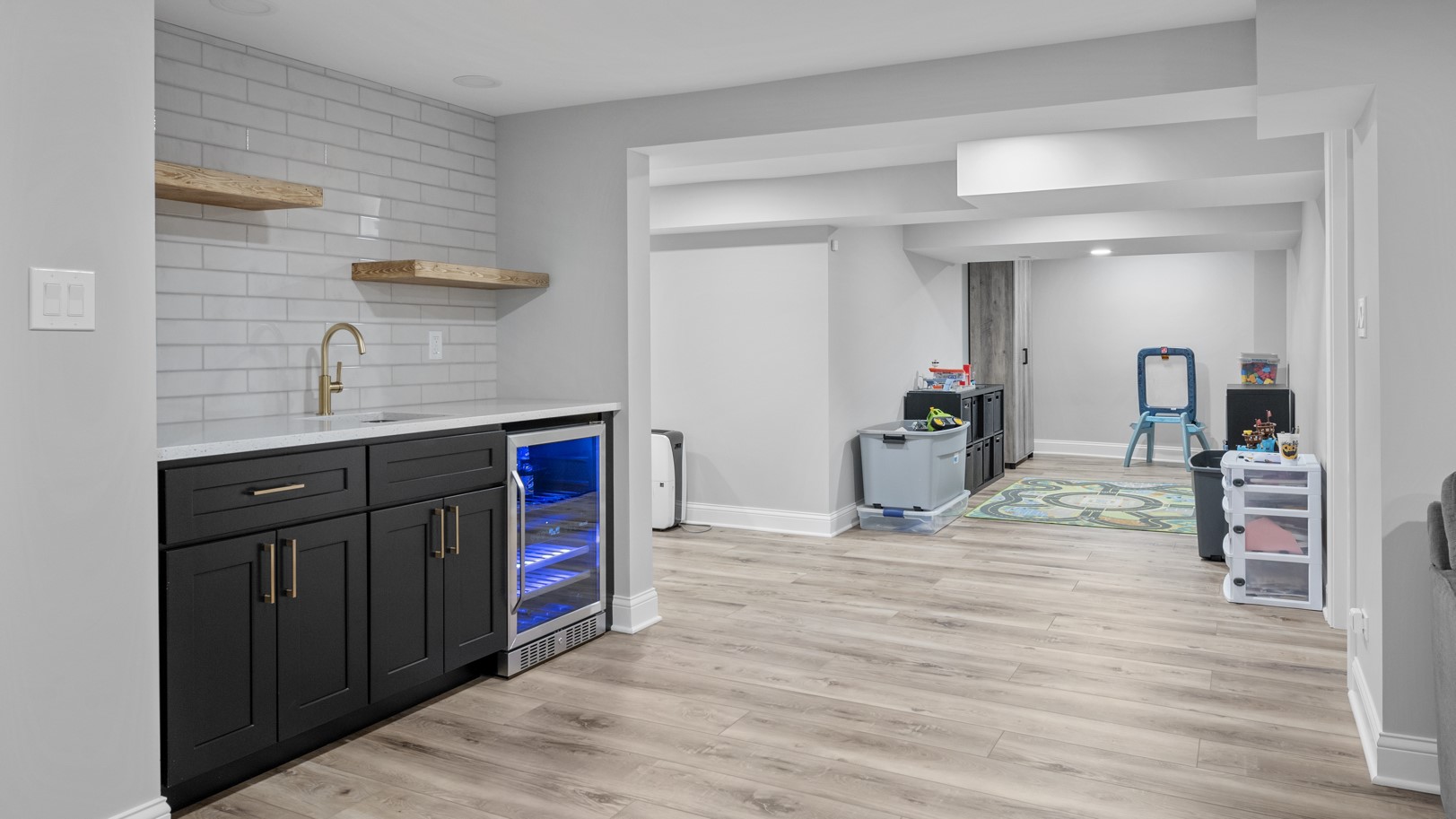 Luxury basement remodel by the 4Ever Remodeling team in Oak Park, IL | New laminate floors and beautiful dark wood cabinets and children’s play space