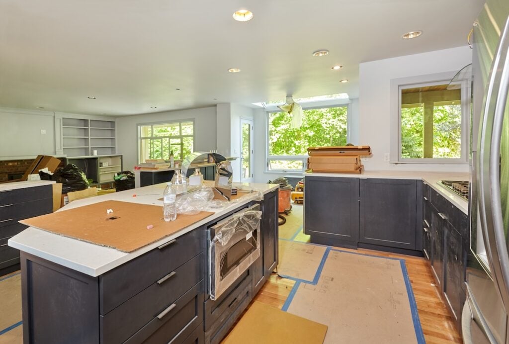 Partially finished kitchen remodel is a mess of boxes, plastic bags, tools and trash