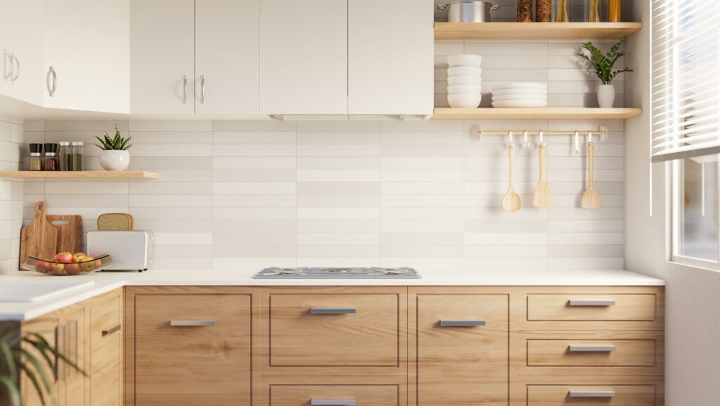 Interior design of a beautiful modern kitchen with minimal classic wood kitchen cabinet, white tiles wall, and kitchen appliances.