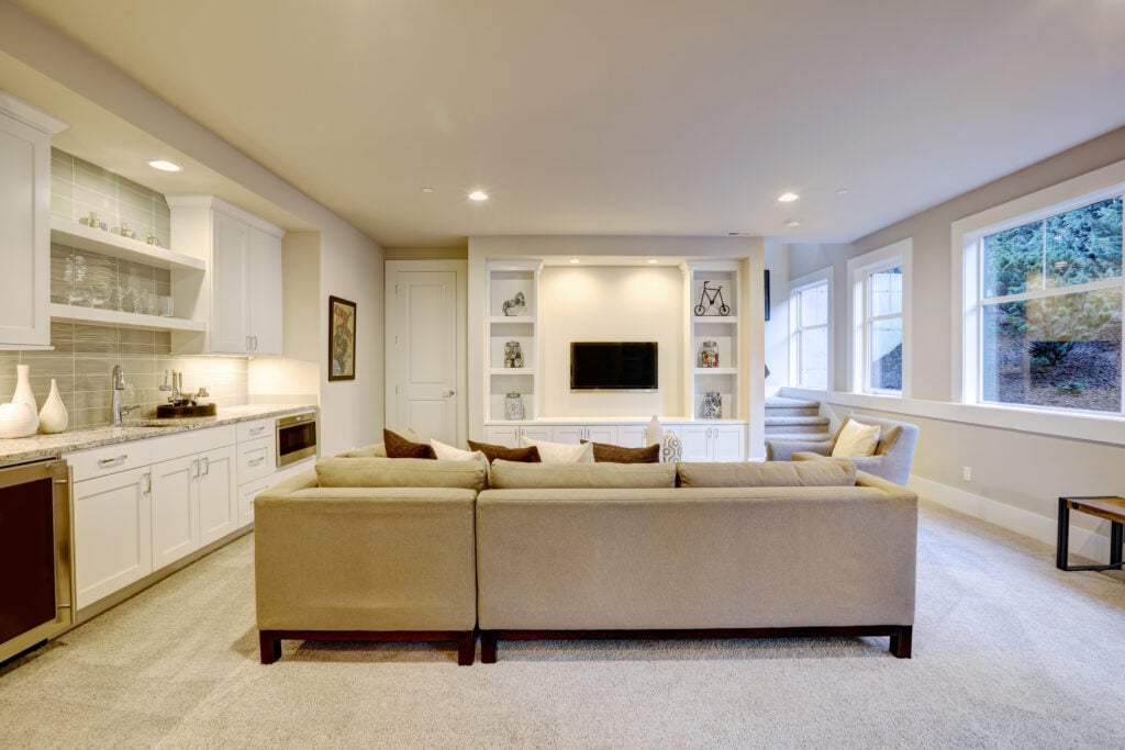 wet bar ideas for basement Chic basement features a gray sectional facing a white built-in tv cabinet and wet bar mounted to a wall. Northwest, USA