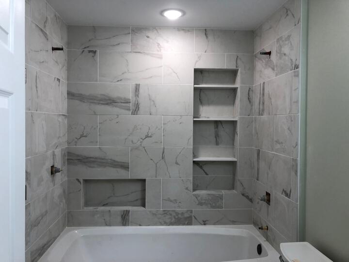 grey and white bathroom with lights on