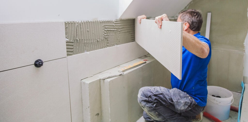 guy installing new tiles on a wall